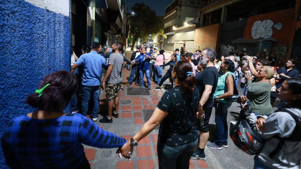  A group of people hold hands in protest to be let in to count the votes during the presidential election on July 28, 2024 in Caracas, Venezuela. 