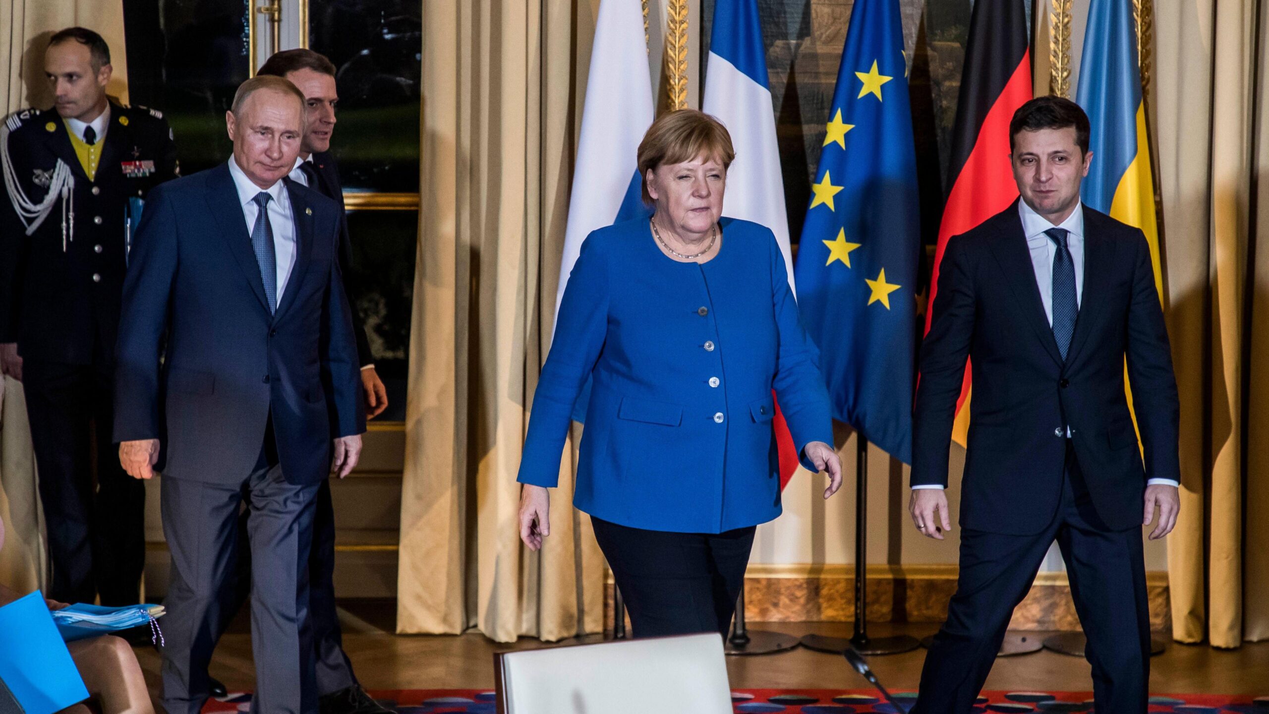 Angela Merkel walks towards the camera alongside Vladimir Putin and Volodymyr Zelensky at a meeting in Paris in 2019