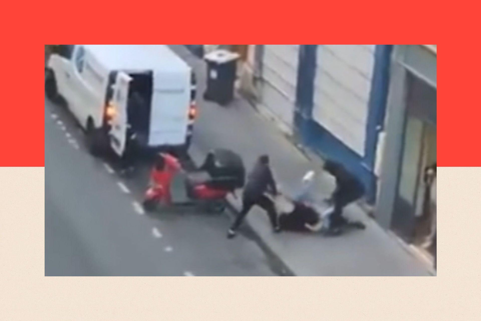 A still from a video shows two men in black trying to drag a woman into their white van
