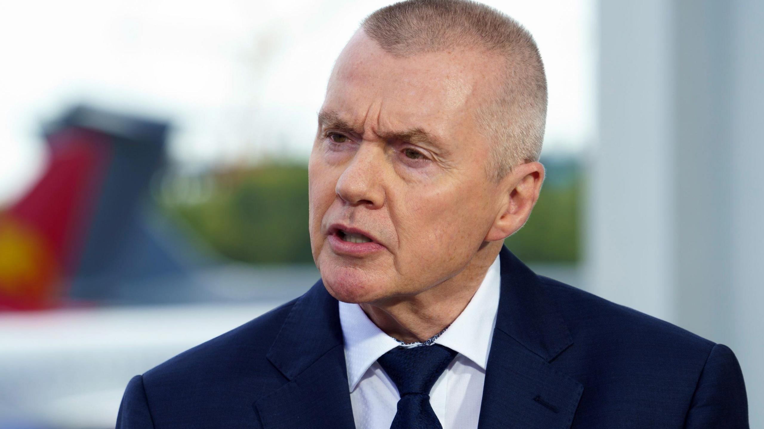 Willie Walsh wears a suit and tie.